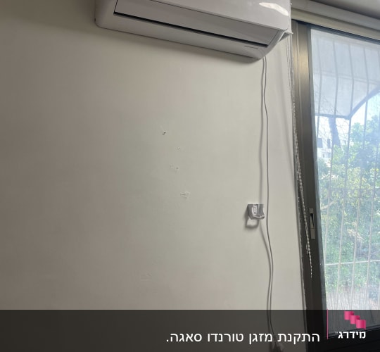 מזגן מותקן על קיר ליד חלון